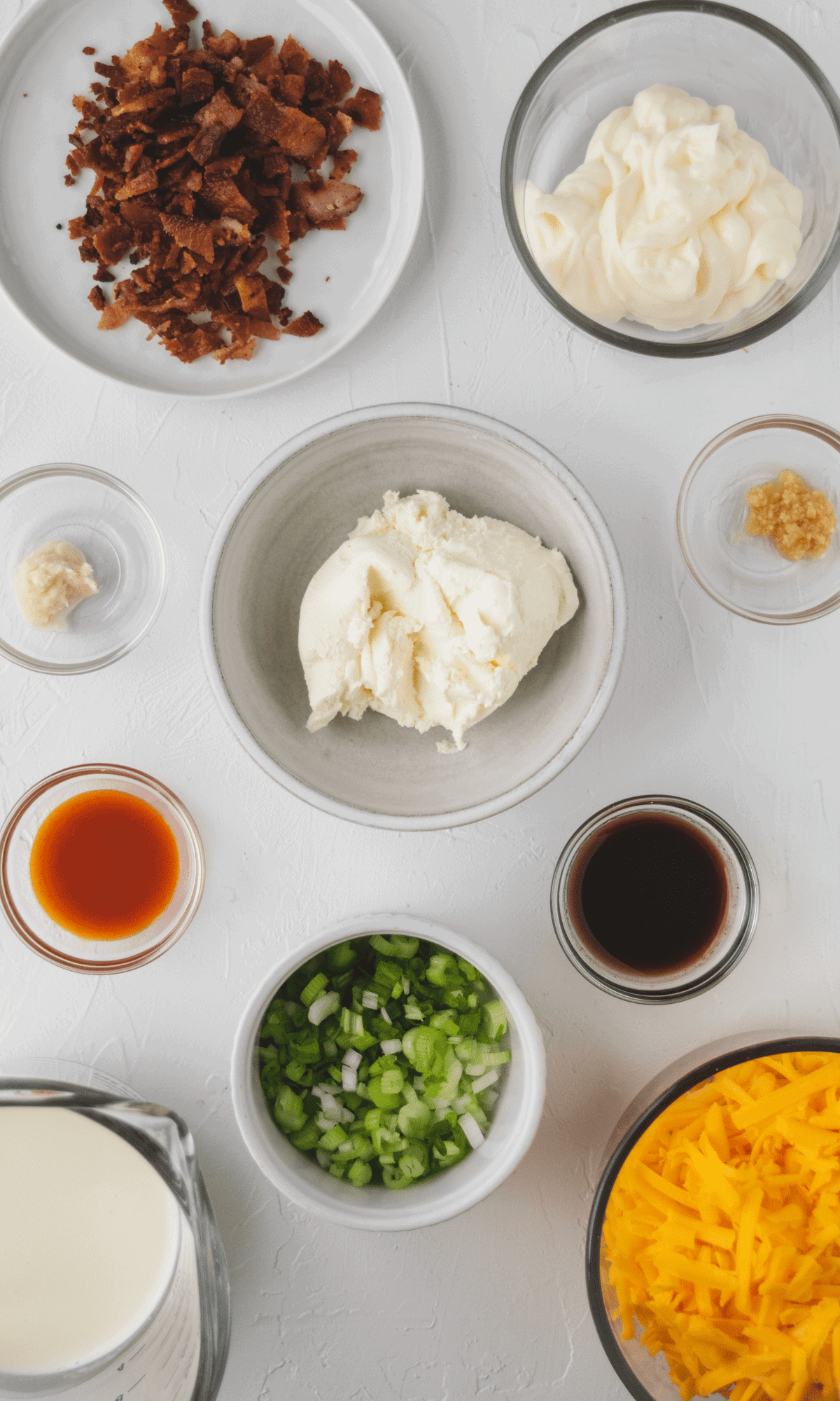 An overhead view of ingredients for Pretzel Dip in varying bowl sizes and shapes.