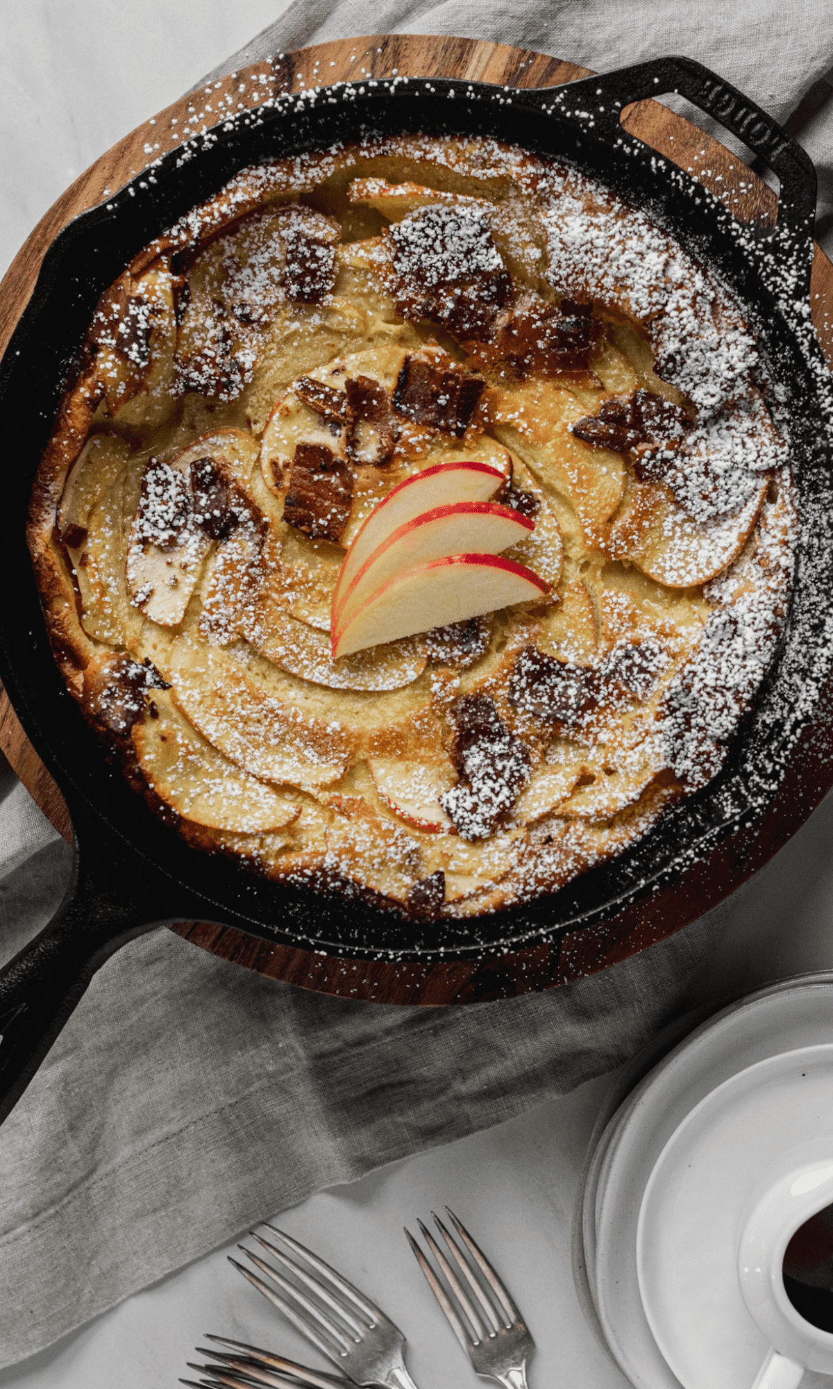 Overhead shot of Bacon Apple Dutch Baby with dusting of powdered sugar.