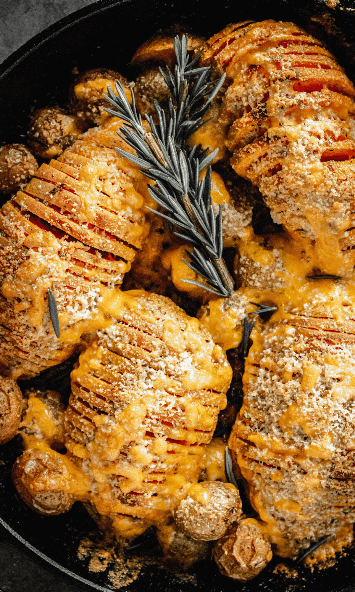 Overhead shot of Cheesy Hasselback Sweet Potatoes in cast iron skillet.