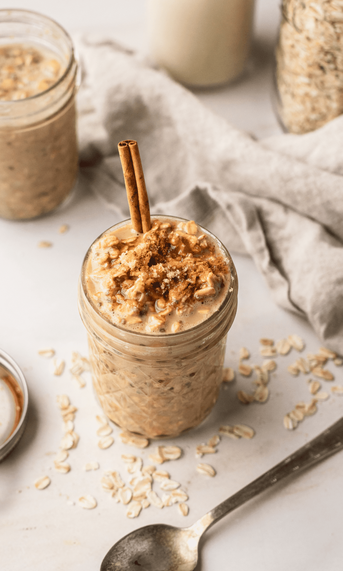 Coffee Overnight Oats in a mason jar with a cinnamon stick sticking out of the top.