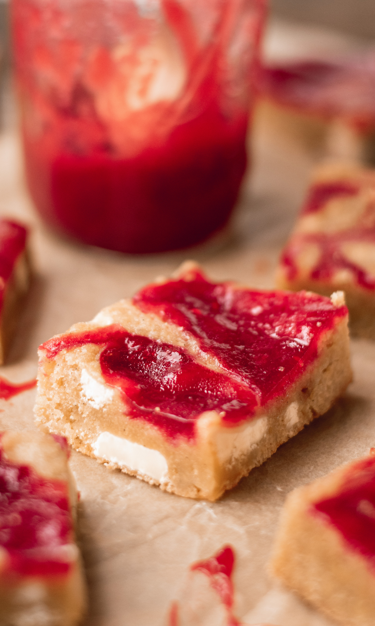 Raspberry and white chocolate blondies on brown parchment paper.