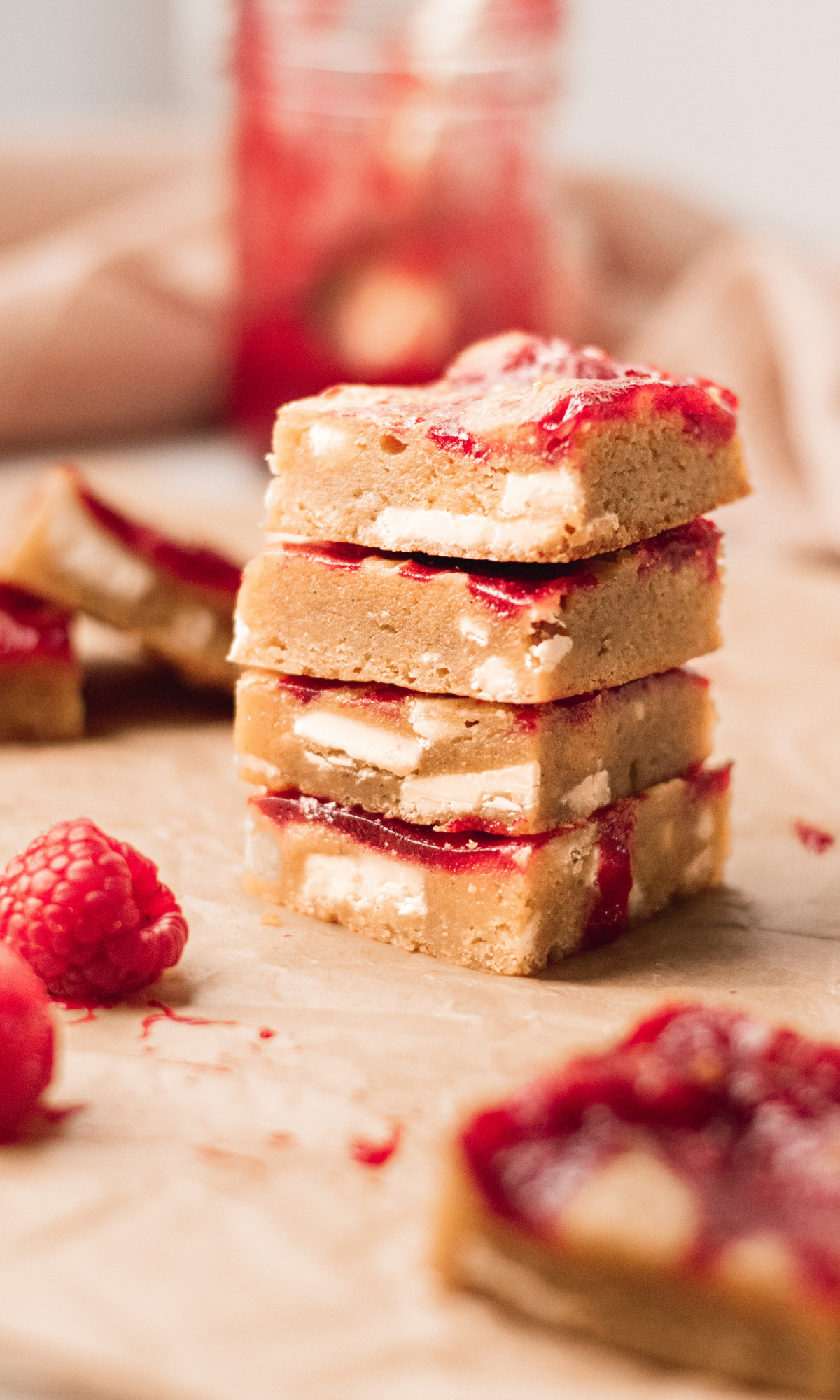 A stack of four raspberry and white chocolate blondies.