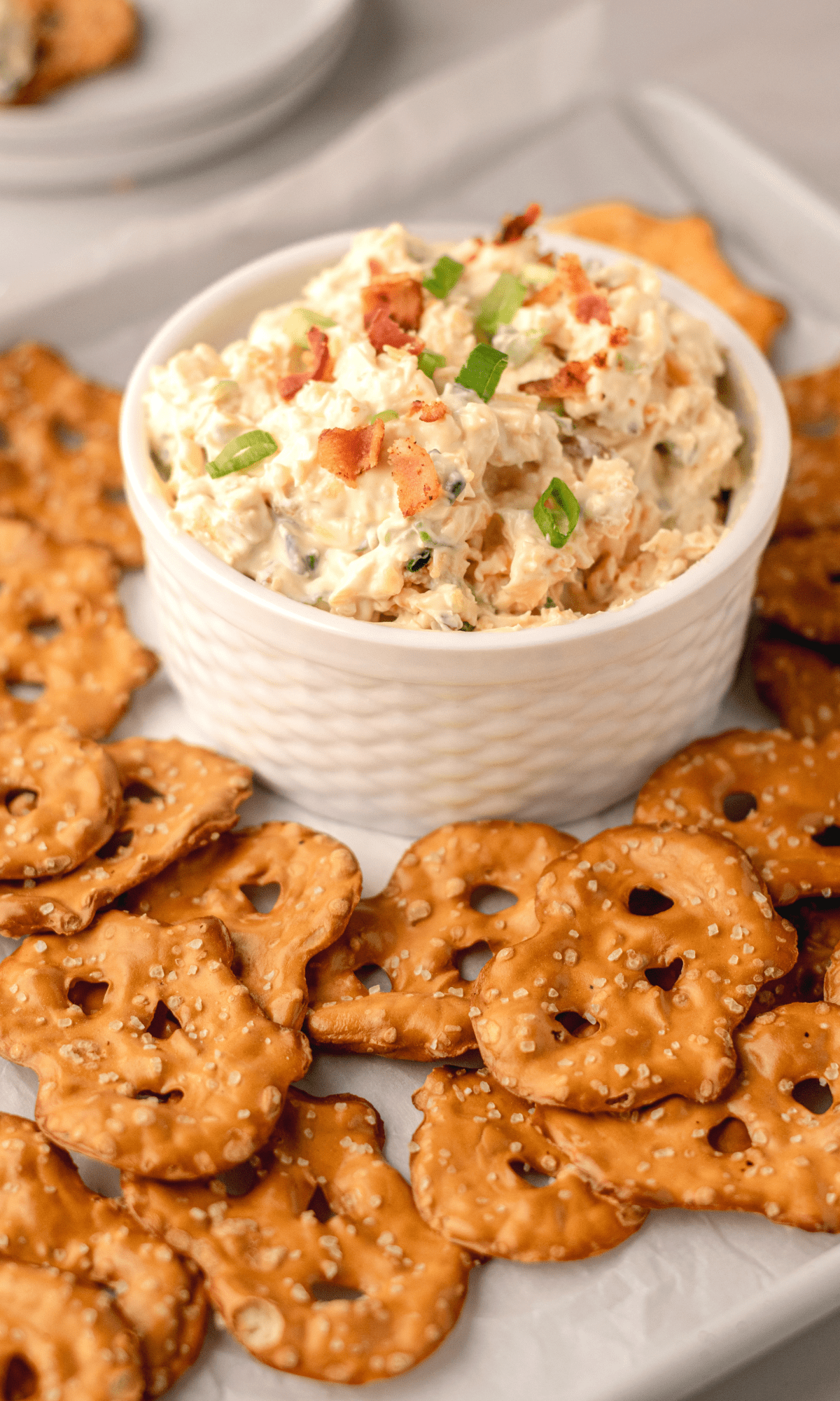 Pretzel Dip in a small white bowl with pretzel crisps around it.