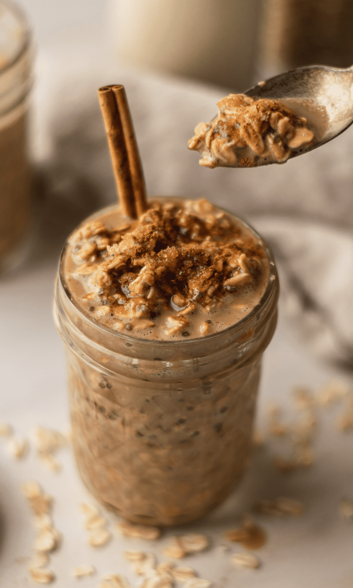 Coffee Overnight Oats in a mason jar with a cinnamon stick sticking out the top.