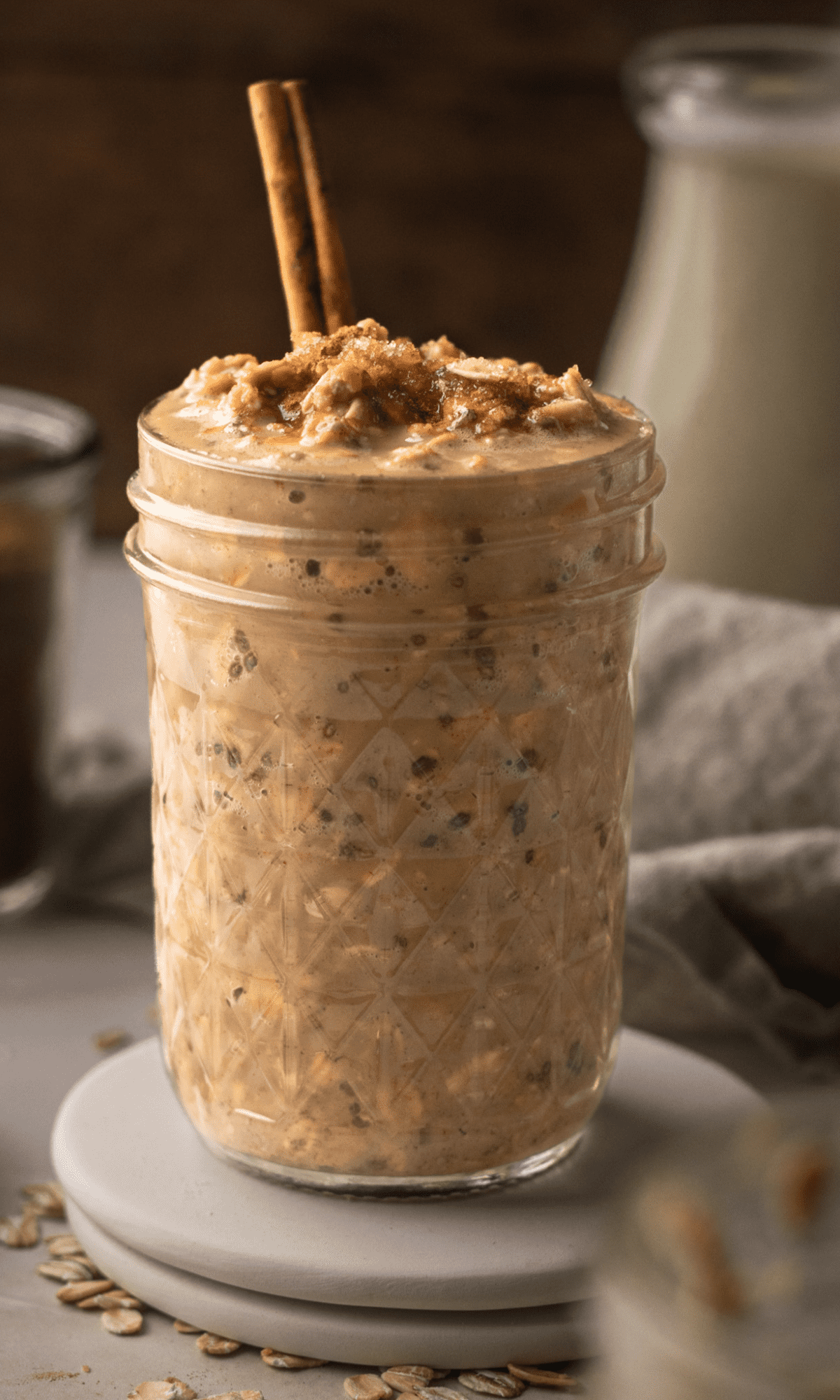 Coffee Overnight Oats in a mason jar with a cinnamon stick sticking out of the top.