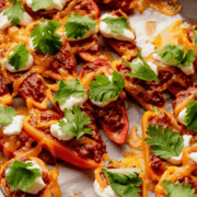 Mini bell pepper nachos with chorizo, sour cream and cilantro.