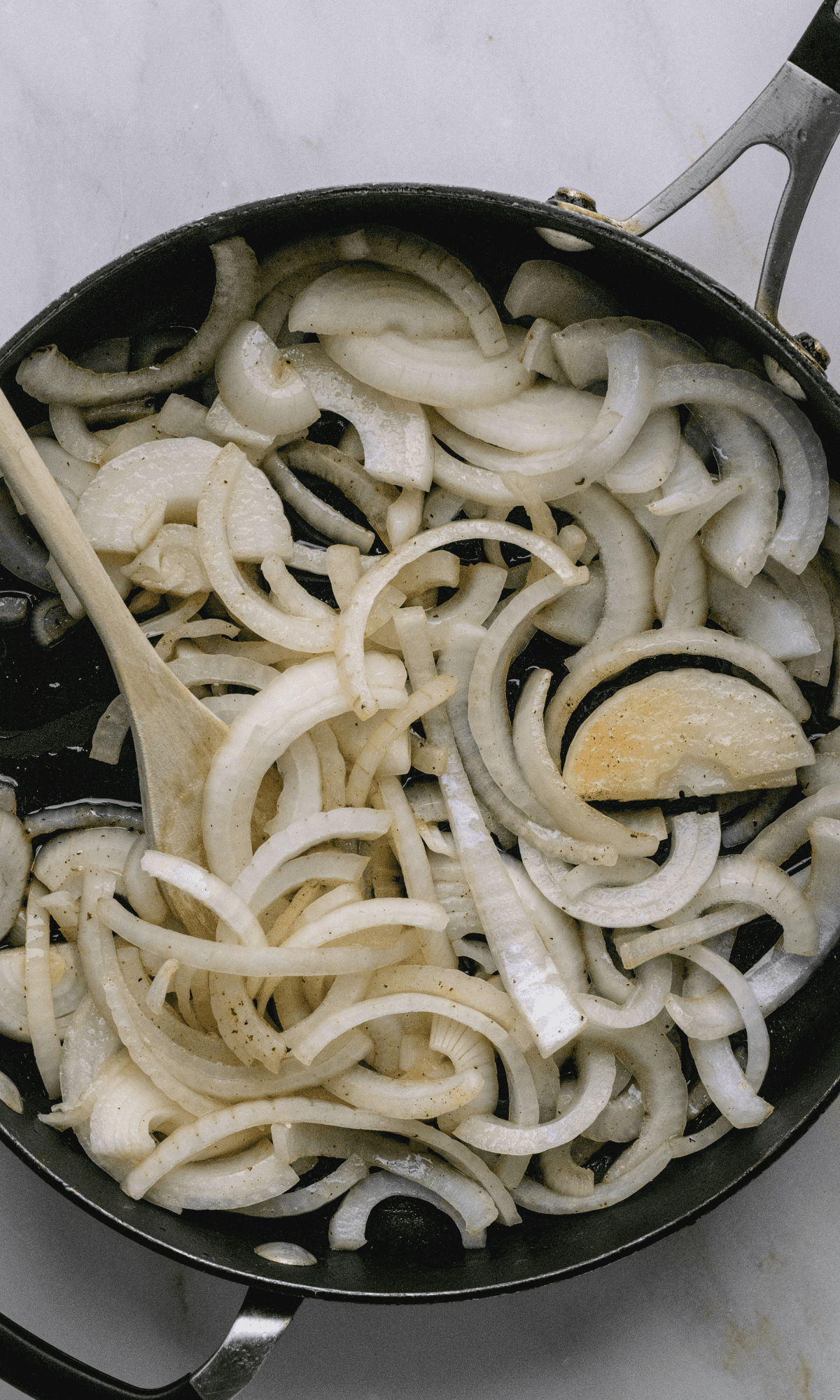 Uncooked onions in skillet.