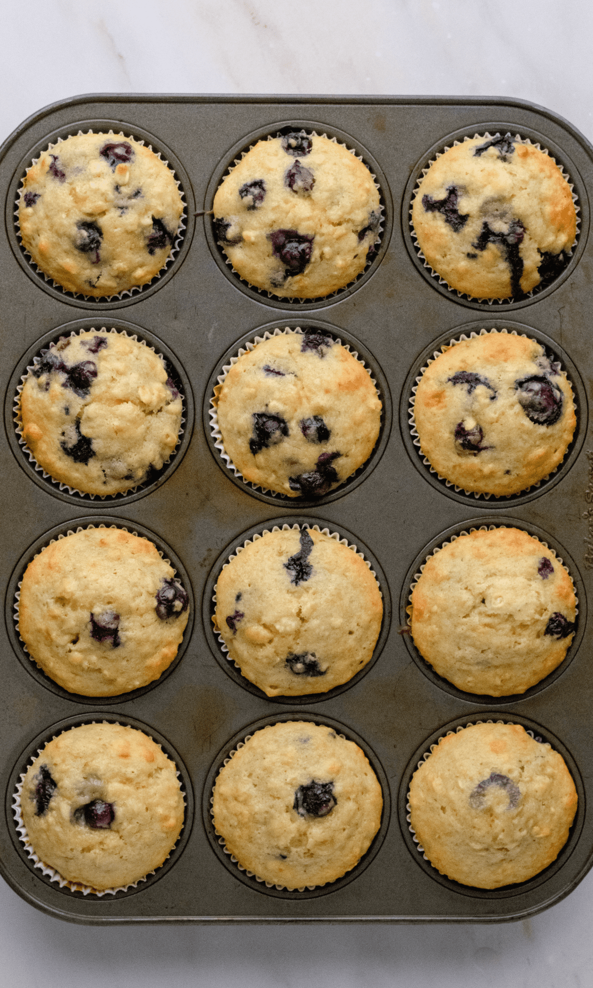 A full pan of baked Oatmeal Blueberry Banana Muffins.