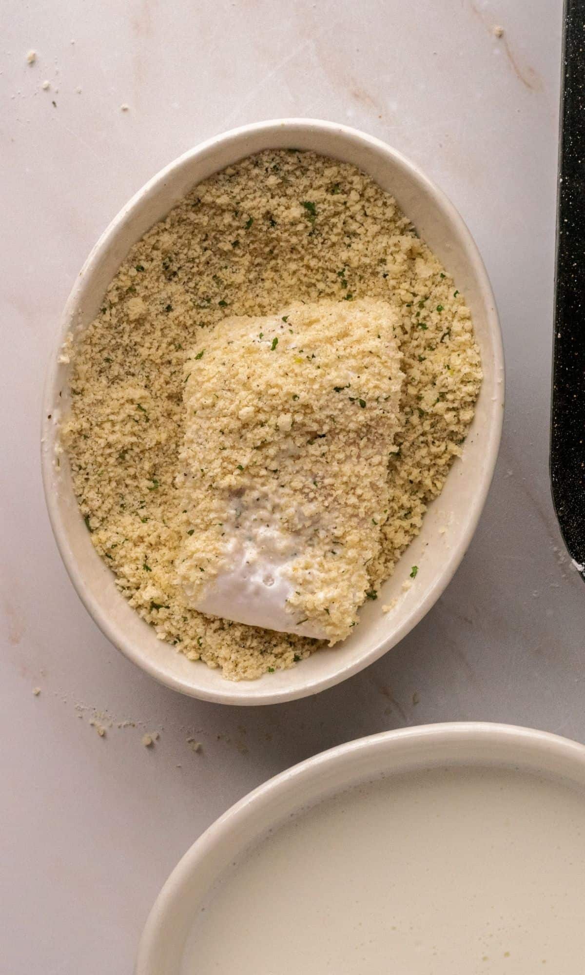 Crunchy Baked Cod with Parmesan Panko Crumbs preparation of dredging in breadcrumb mixture.