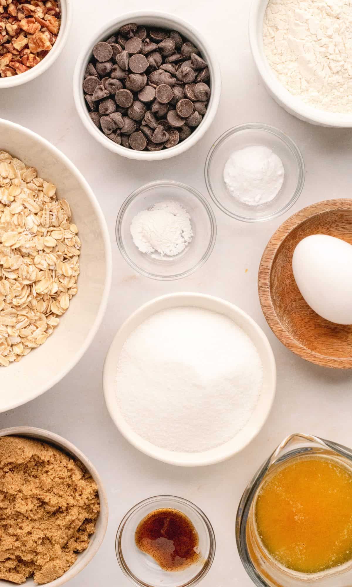 Oatmeal cookie ingredients in varying bowl shapes and sizes.