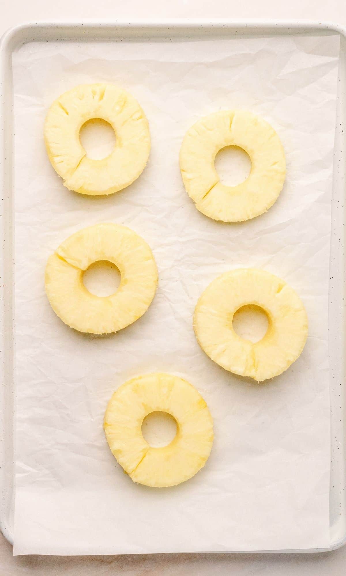 Pineapple slices on white parchment paper.