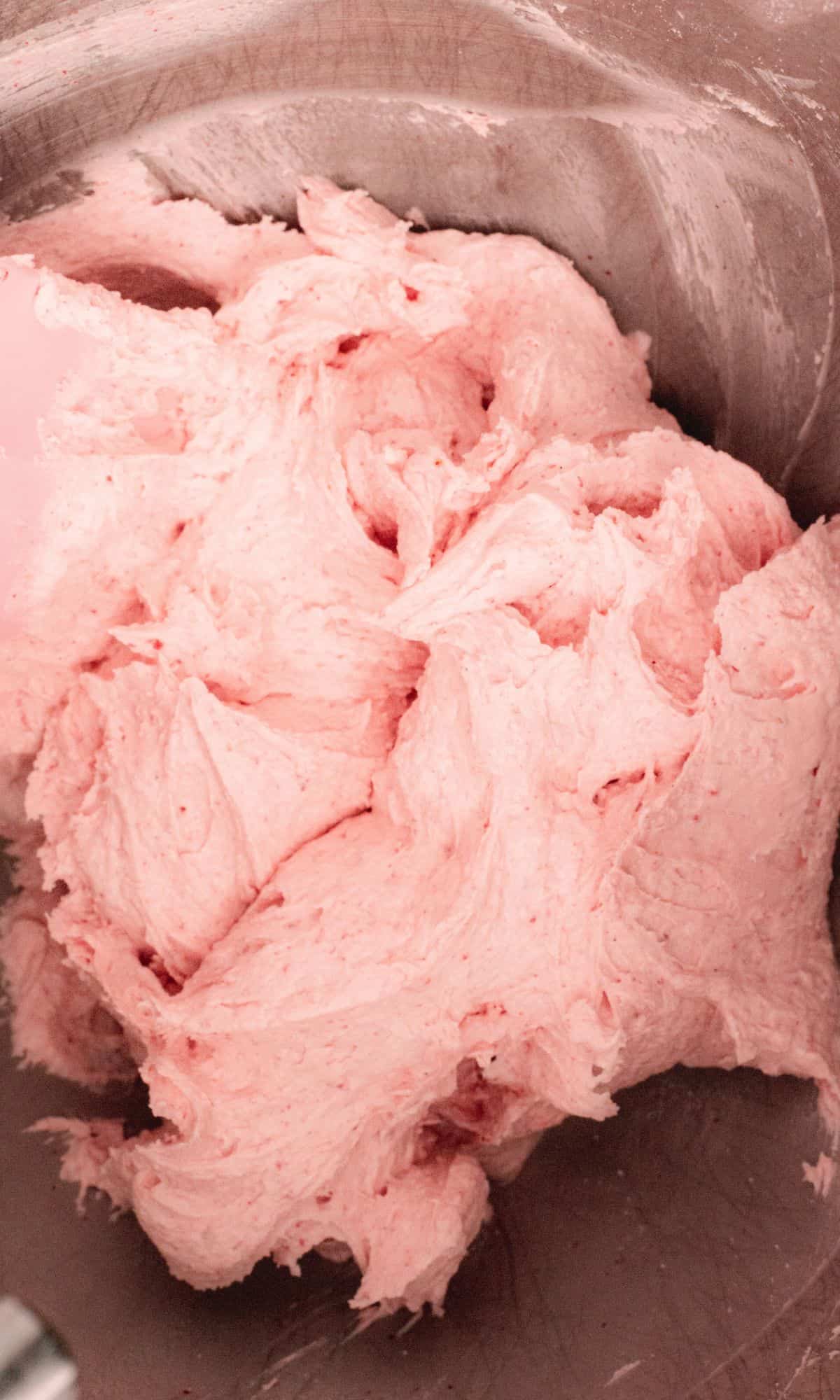 Strawberry buttercream frosting in the bowl of stand mixer.
