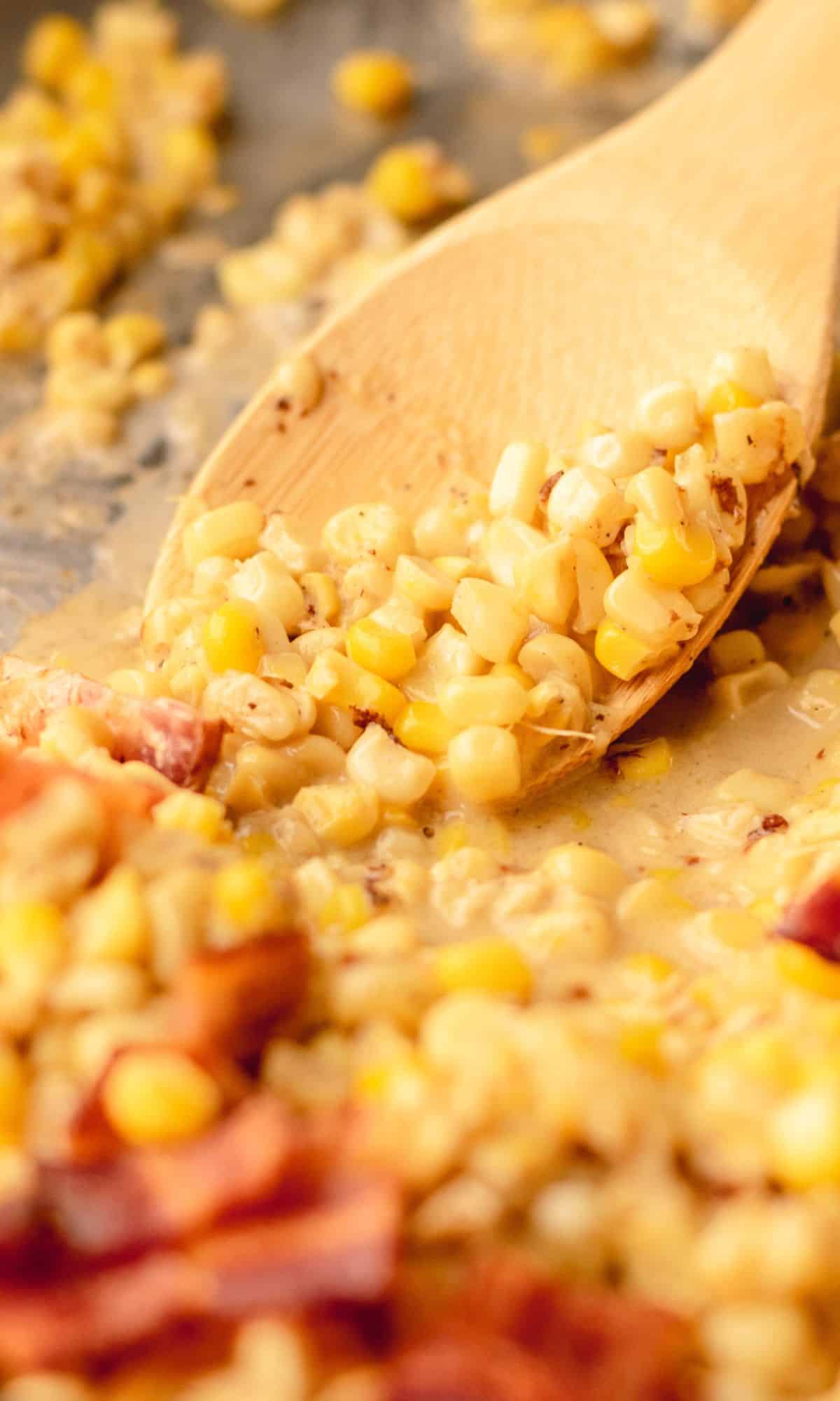 Creamy skillet corn in a skillet topped with bacon.