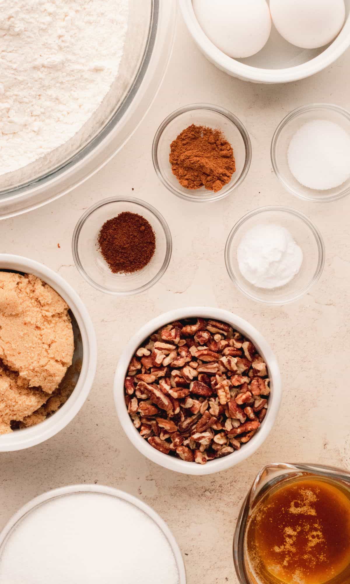 Ingredients for pecan spice cookies in varying bowl shapes and sizes.