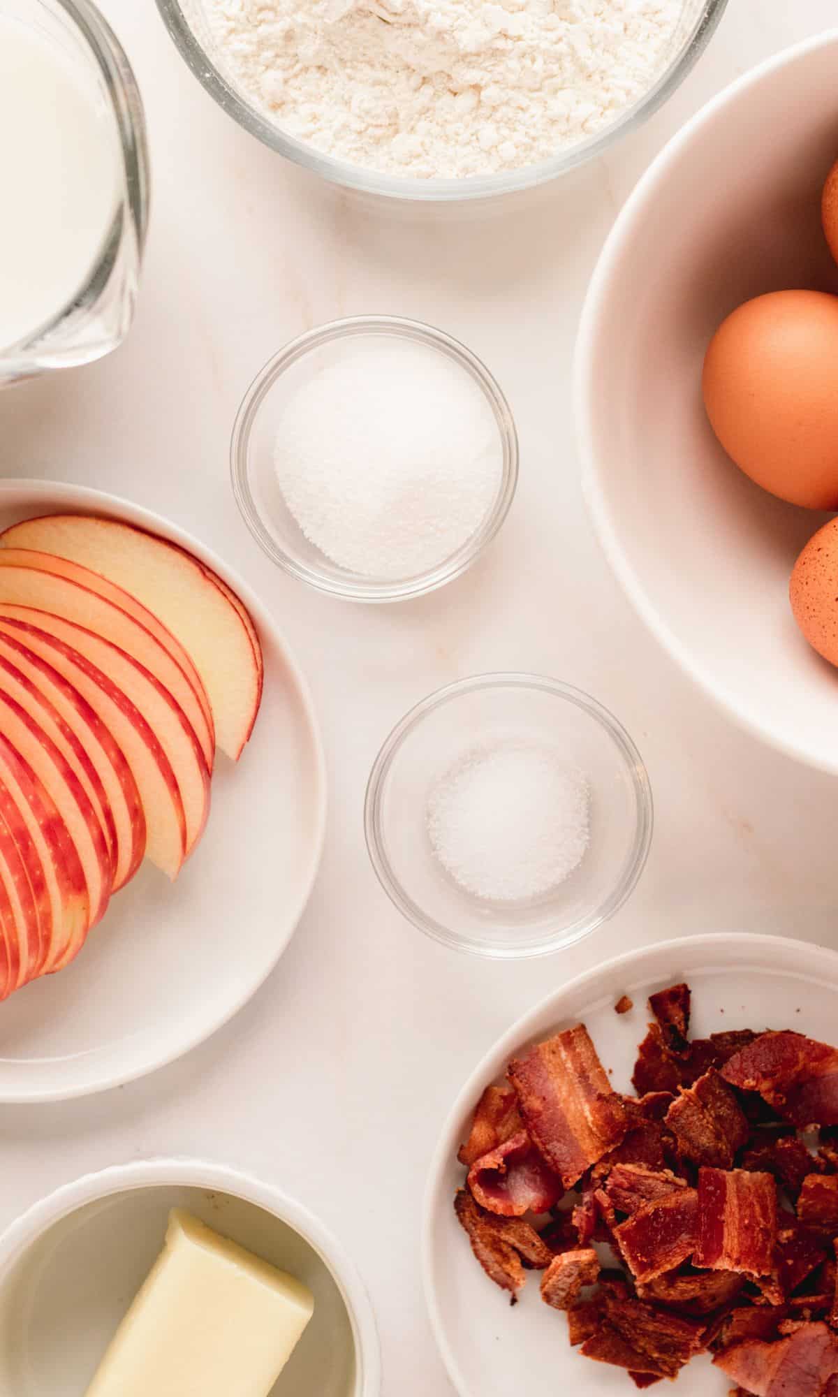 Bacon apple dutch baby ingredients in varying bowl shapes and sizes.