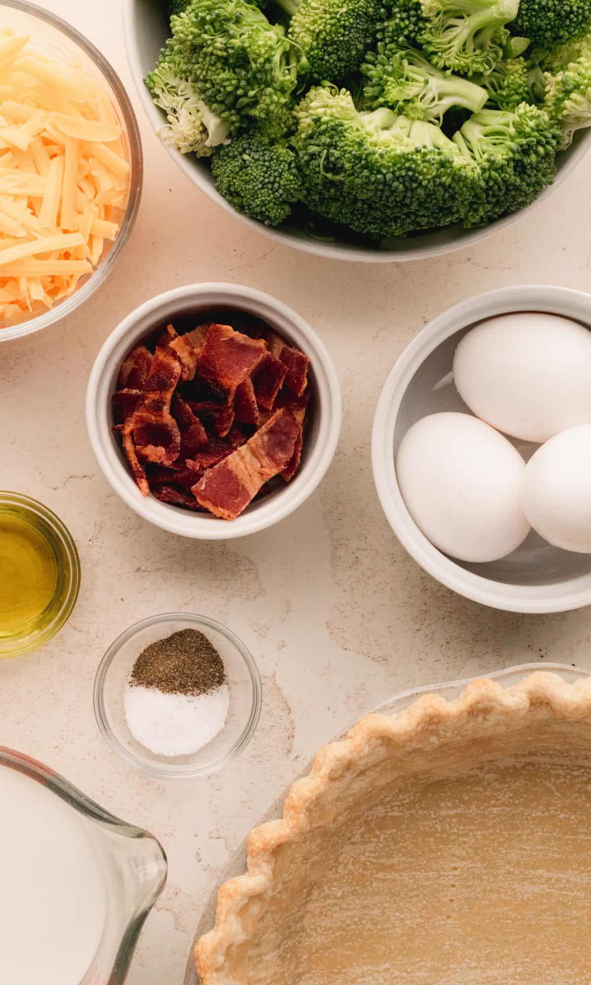 Quiche ingredients in varying bowl shapes and sizes.