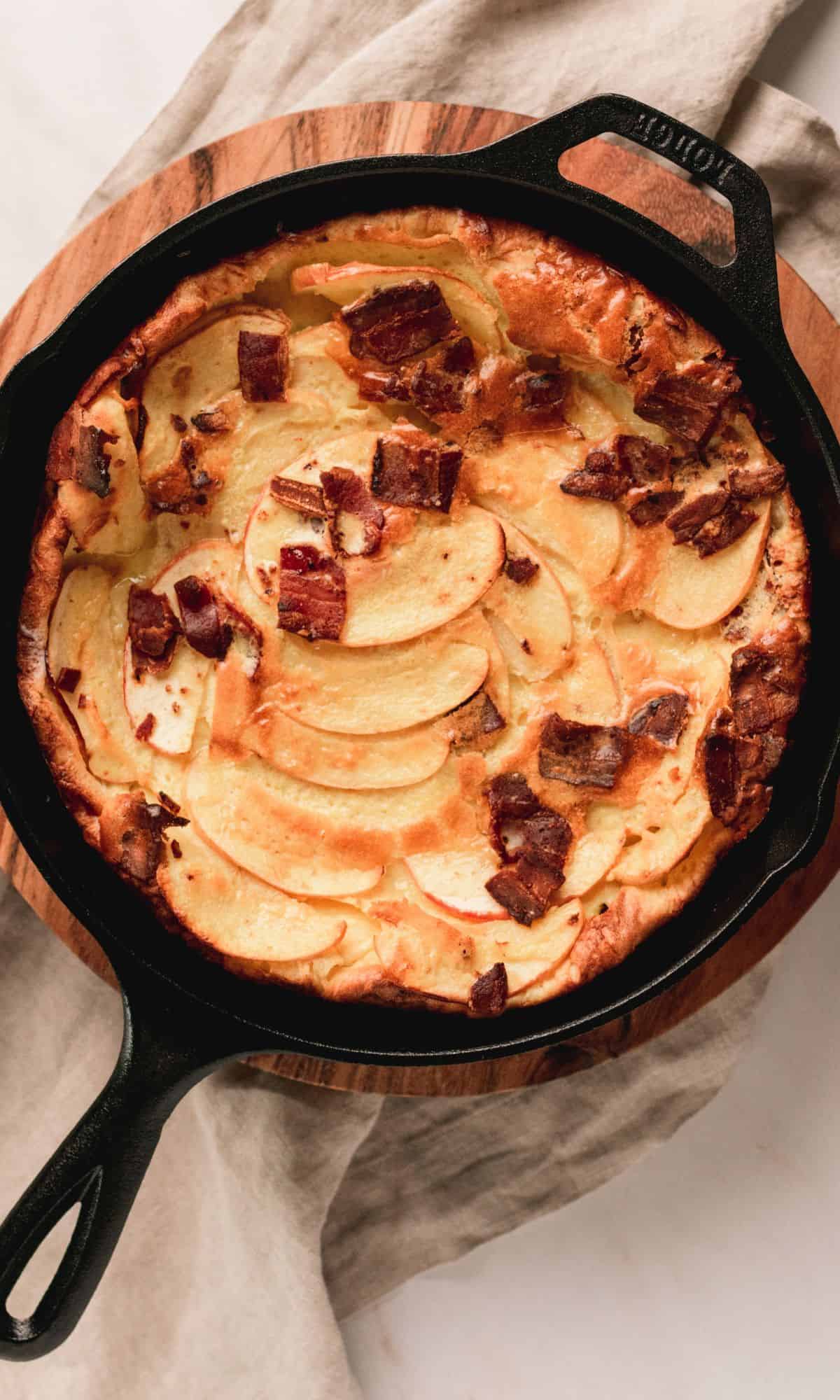 Bacon apple dutch baby in a cast iron skillet.