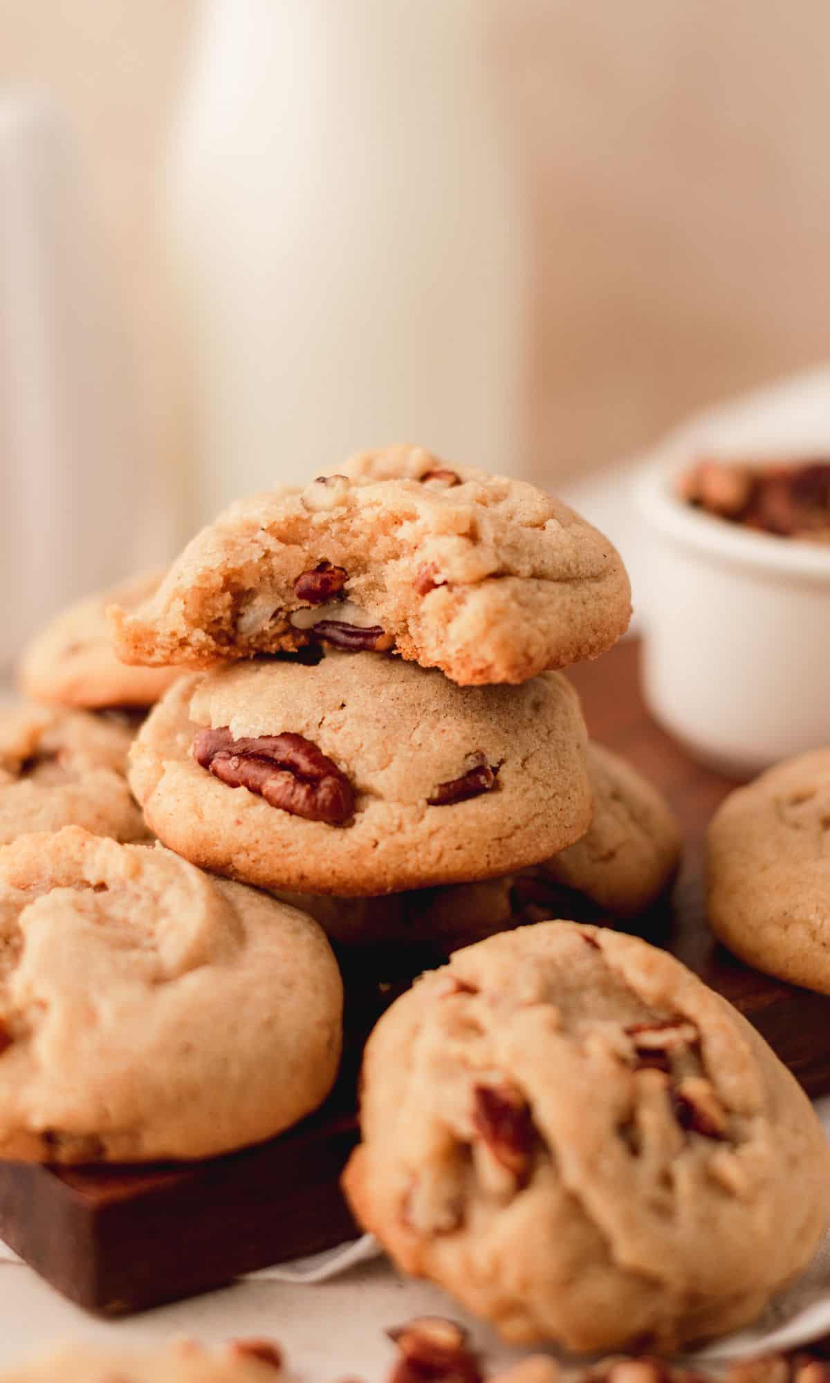 A stack of pecan spice cookies with several more cookies sitting around.