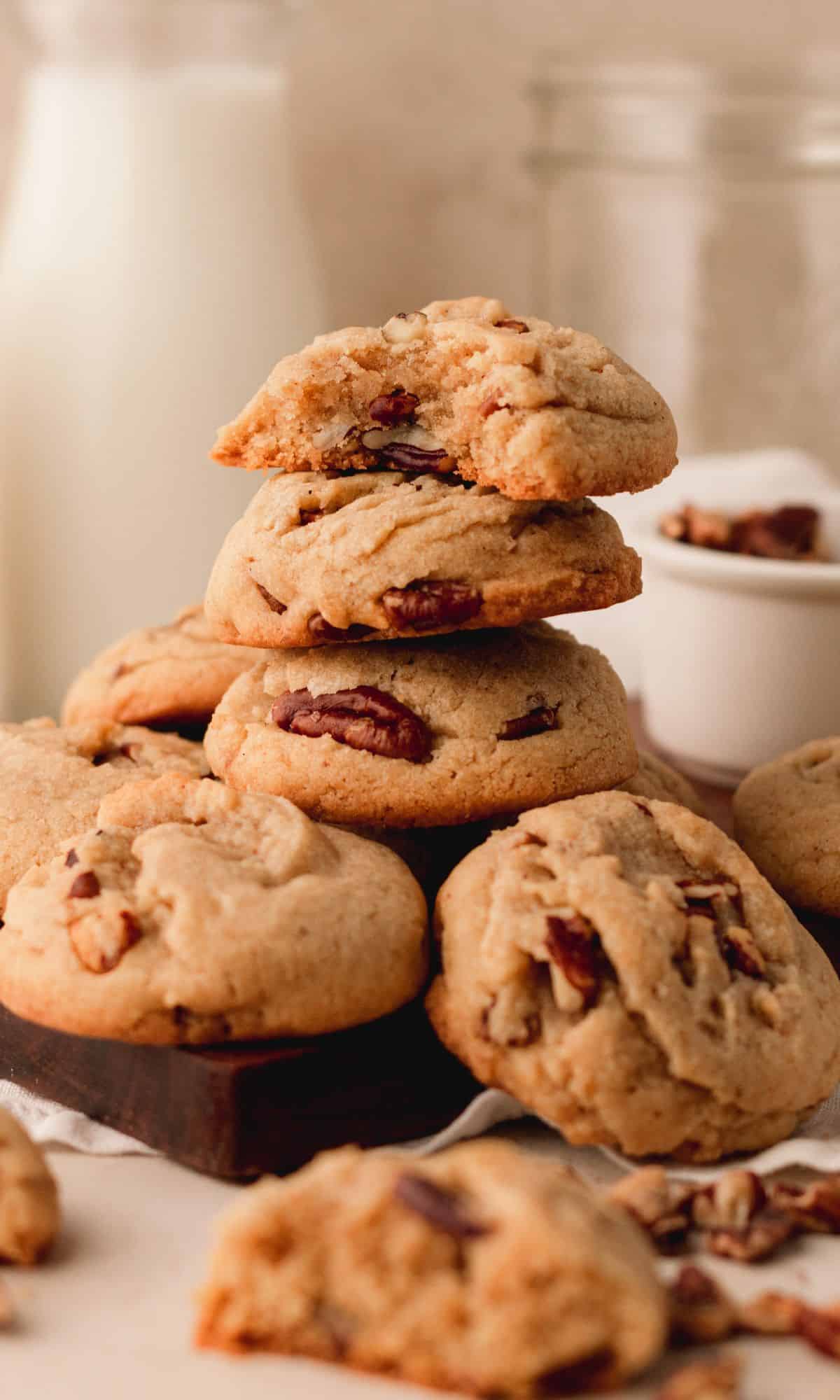 A stack of three pecan spice cookies with a bite out of the top one.