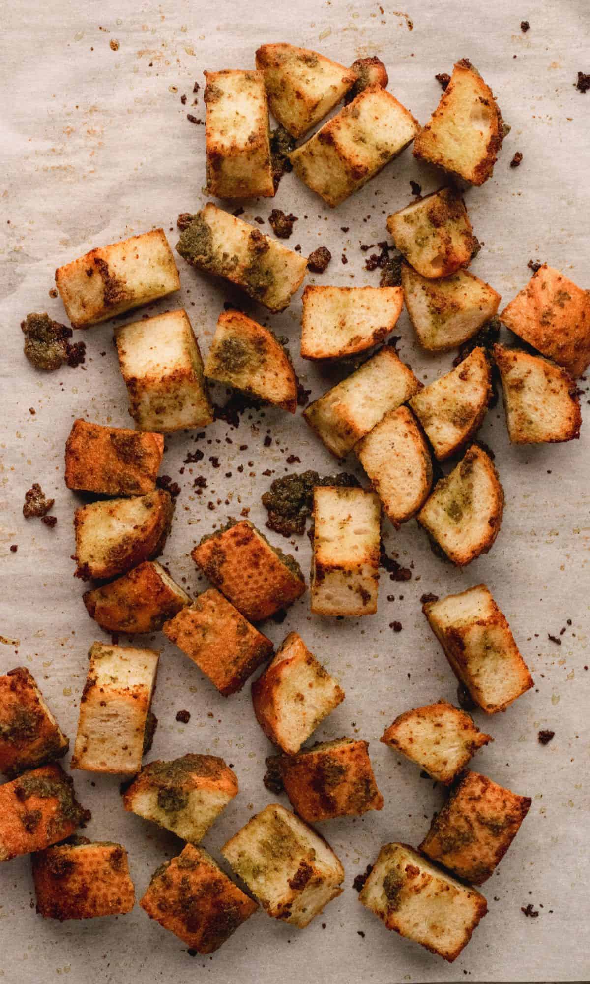 Toasted pesto croutons on a baking sheet.