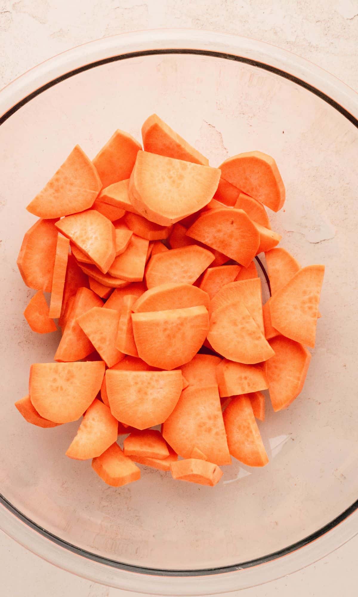Sliced sweet potatoes in a glass bowl.