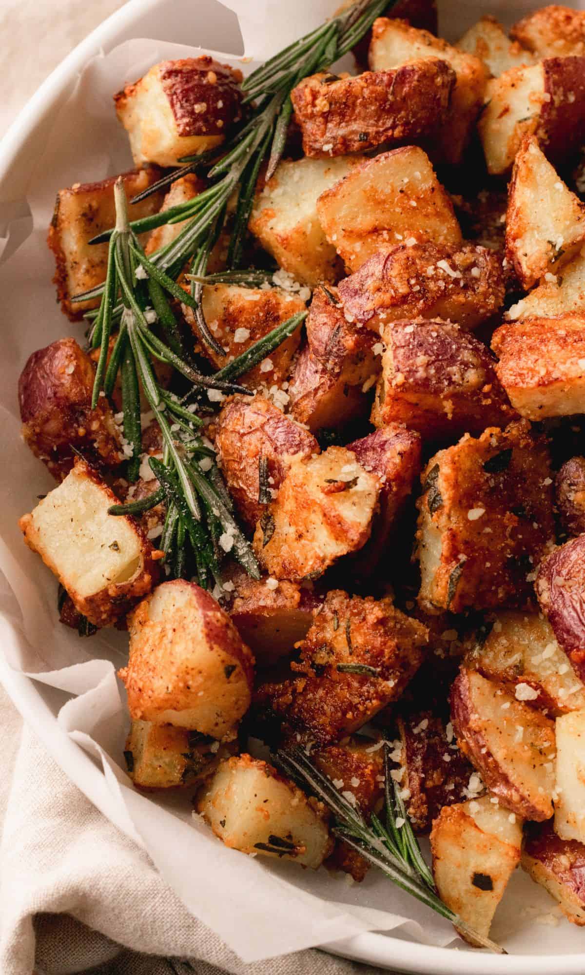 Roasted red potatoes in a white bowl.