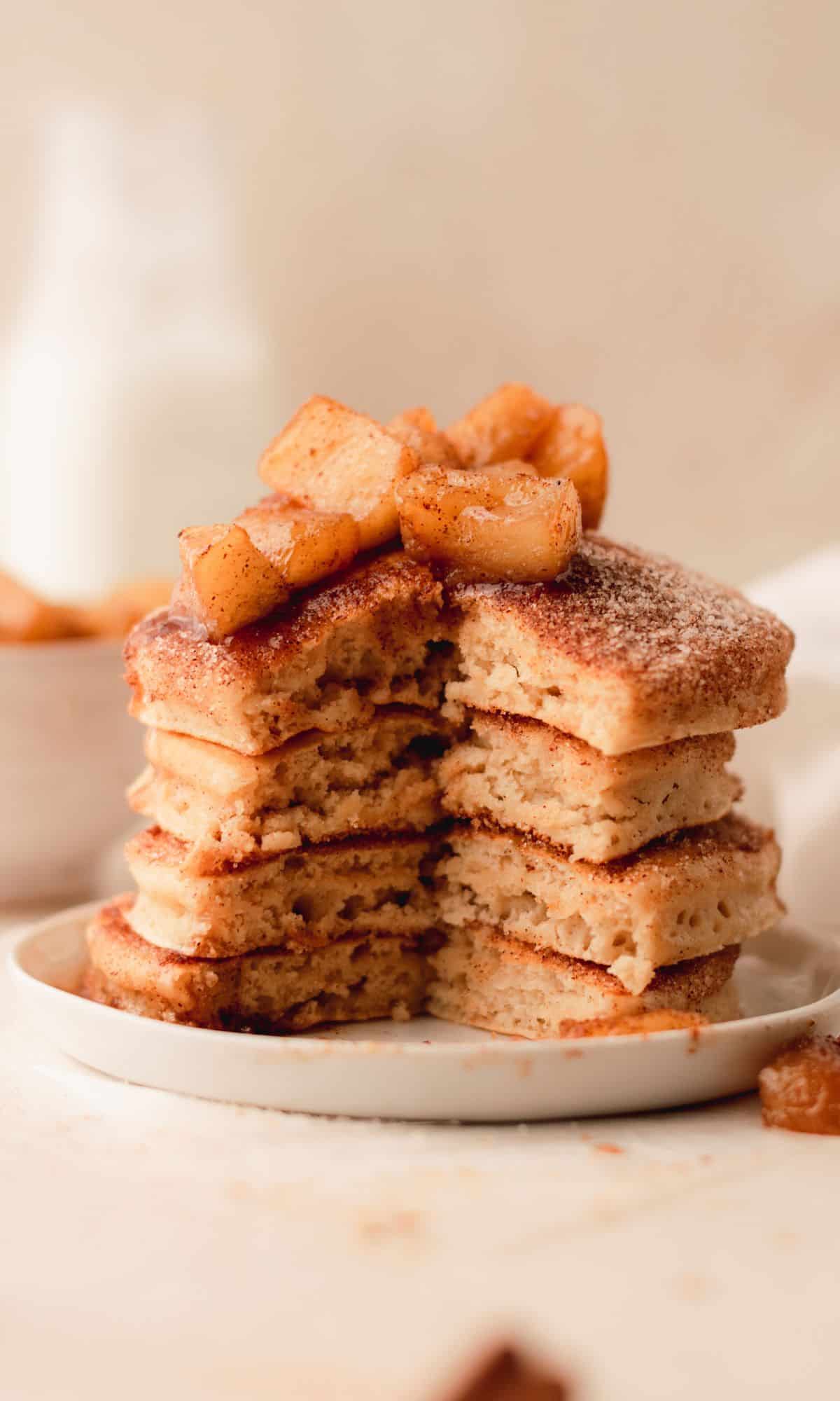 A stack of apple cider pancakes with part of the stack removed.