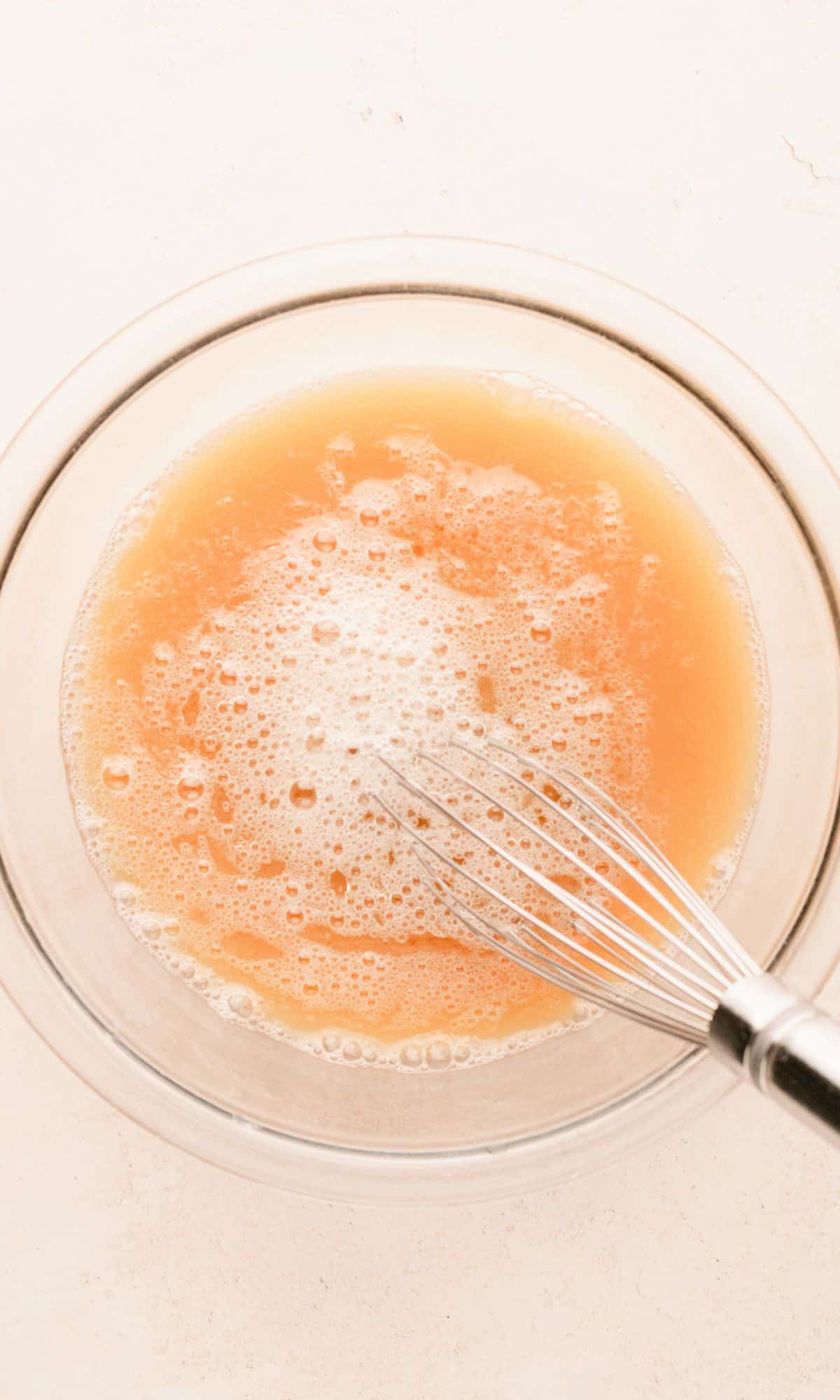 Apple cider pancake preparation in a glass bowl.