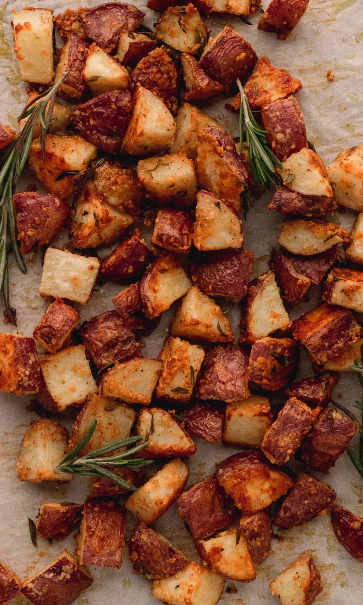 Roasted red potatoes on a baking sheet with parchment paper.