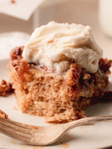 A slice of caramel pecan apple spice upside down cake with ice cream on top.
