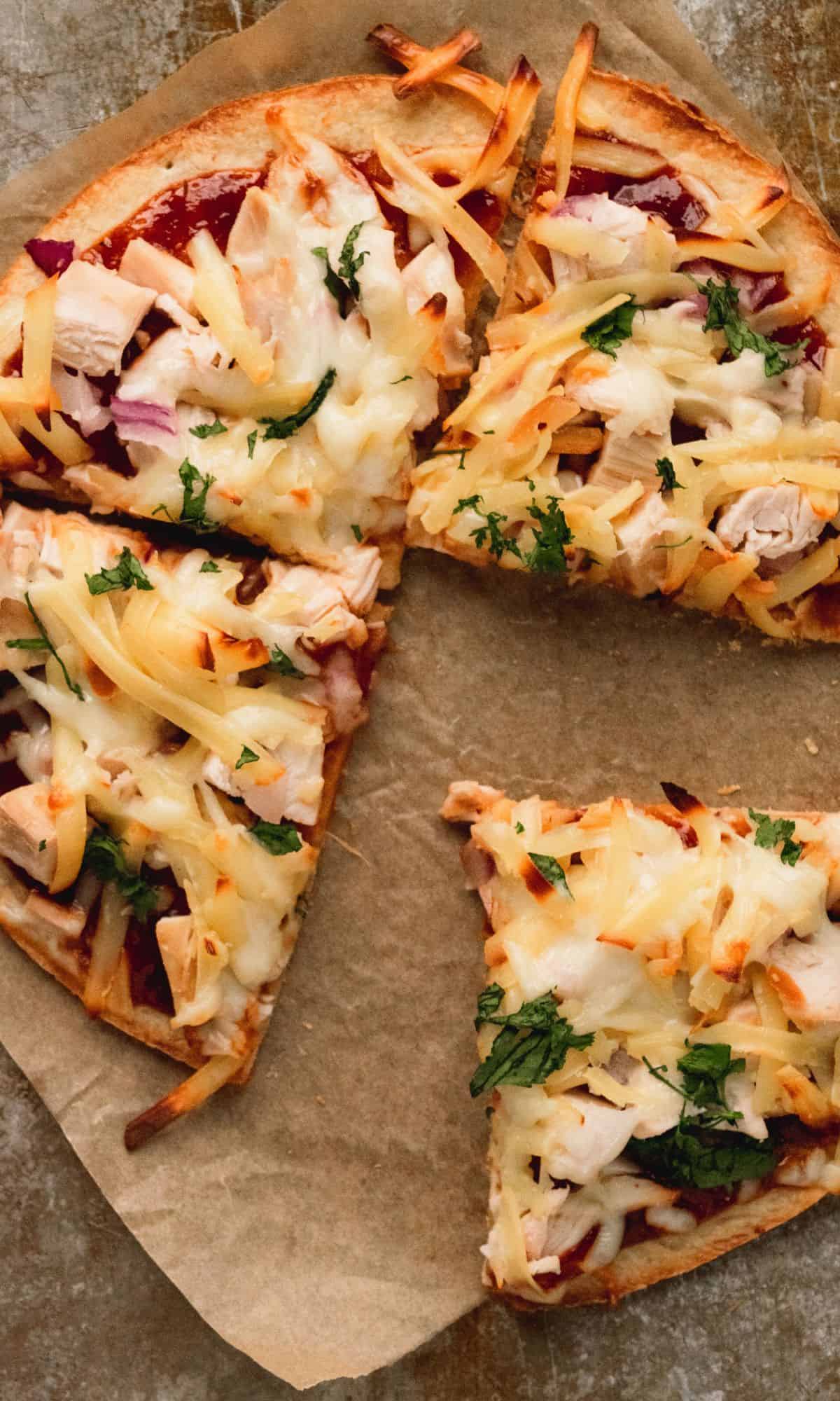 BBQ chicken pizza on brown parchment paper.