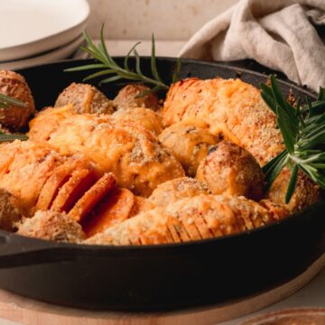 Hasselback sweet potatoes in a cast iron skillet.