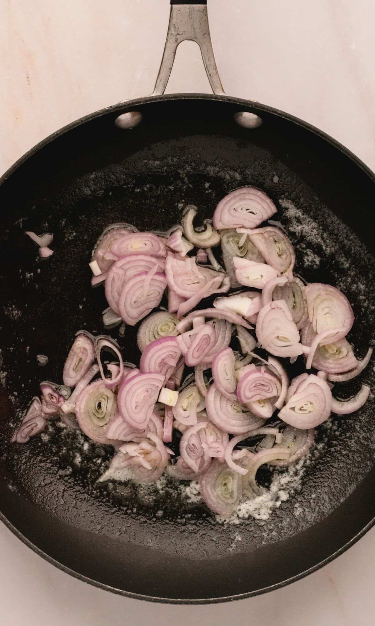 Shallots in a frying pan.