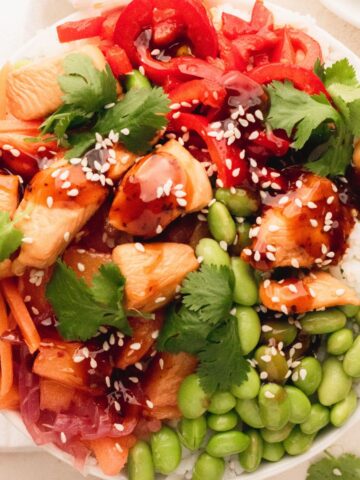Chicken rice bowl with edamame, carrots, red bell pepper and cilantro.