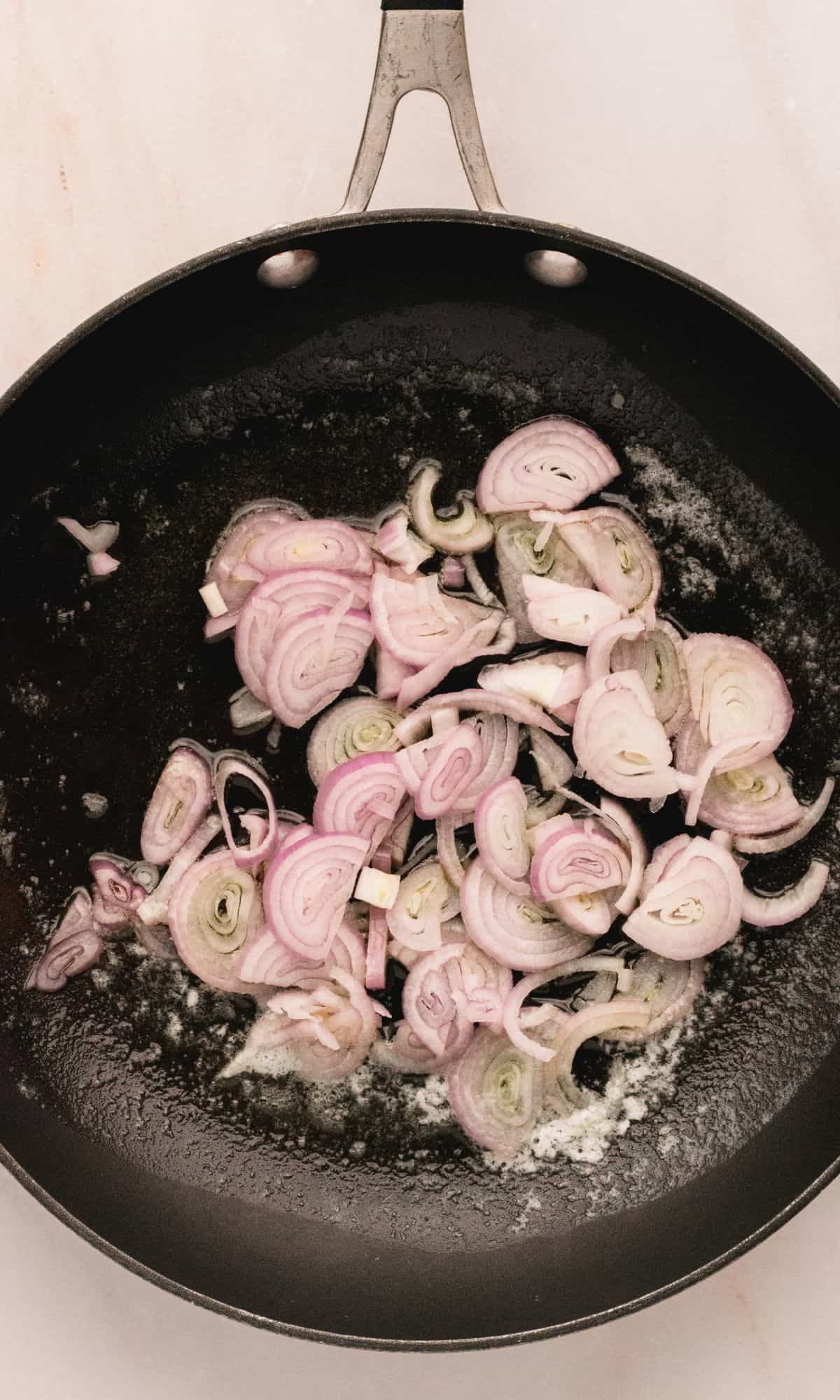 Shallots in a frying pan.