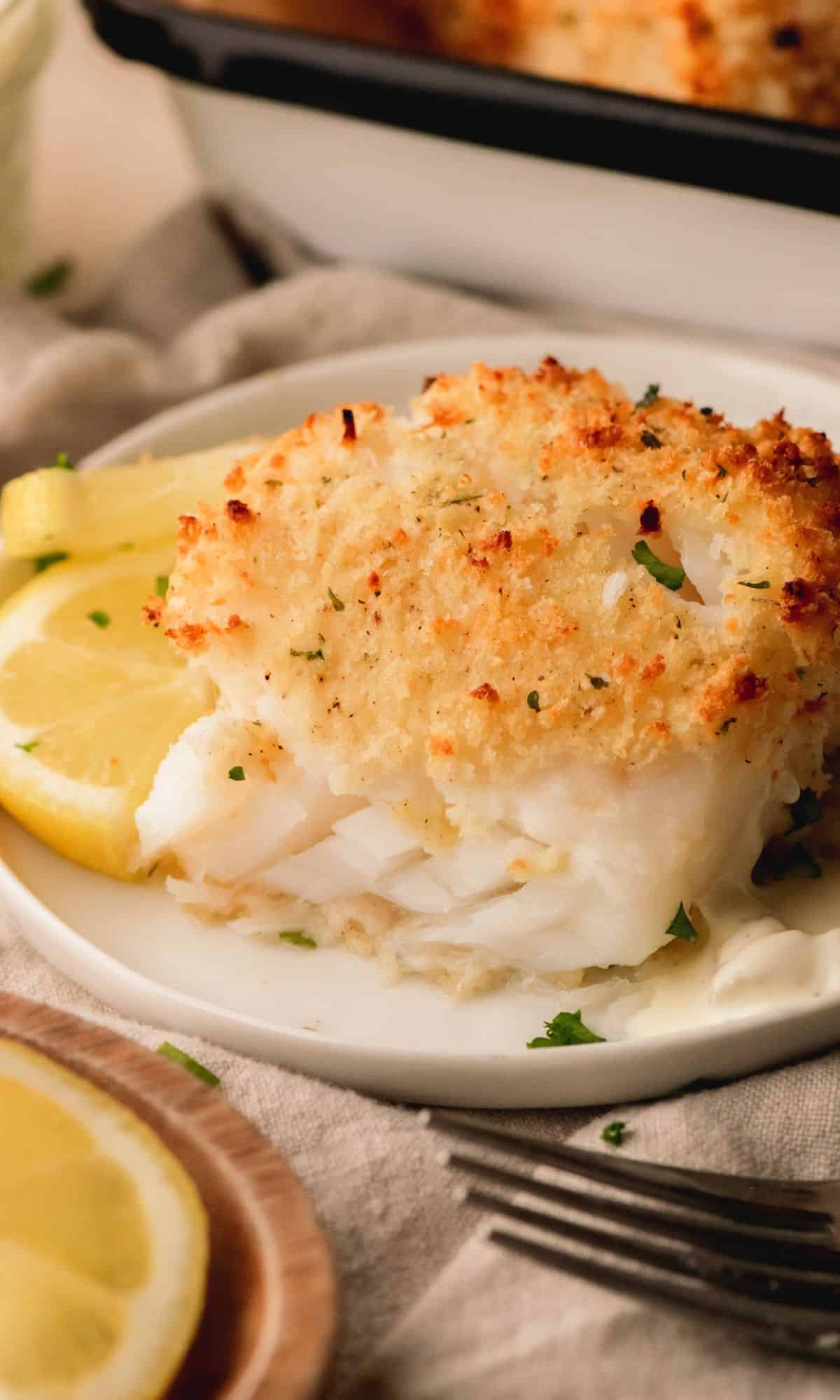 Parmesan baked cod on a white plate.