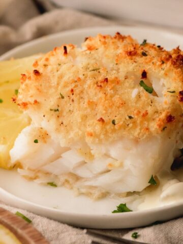 Parmesan panko baked cod on a white plate.