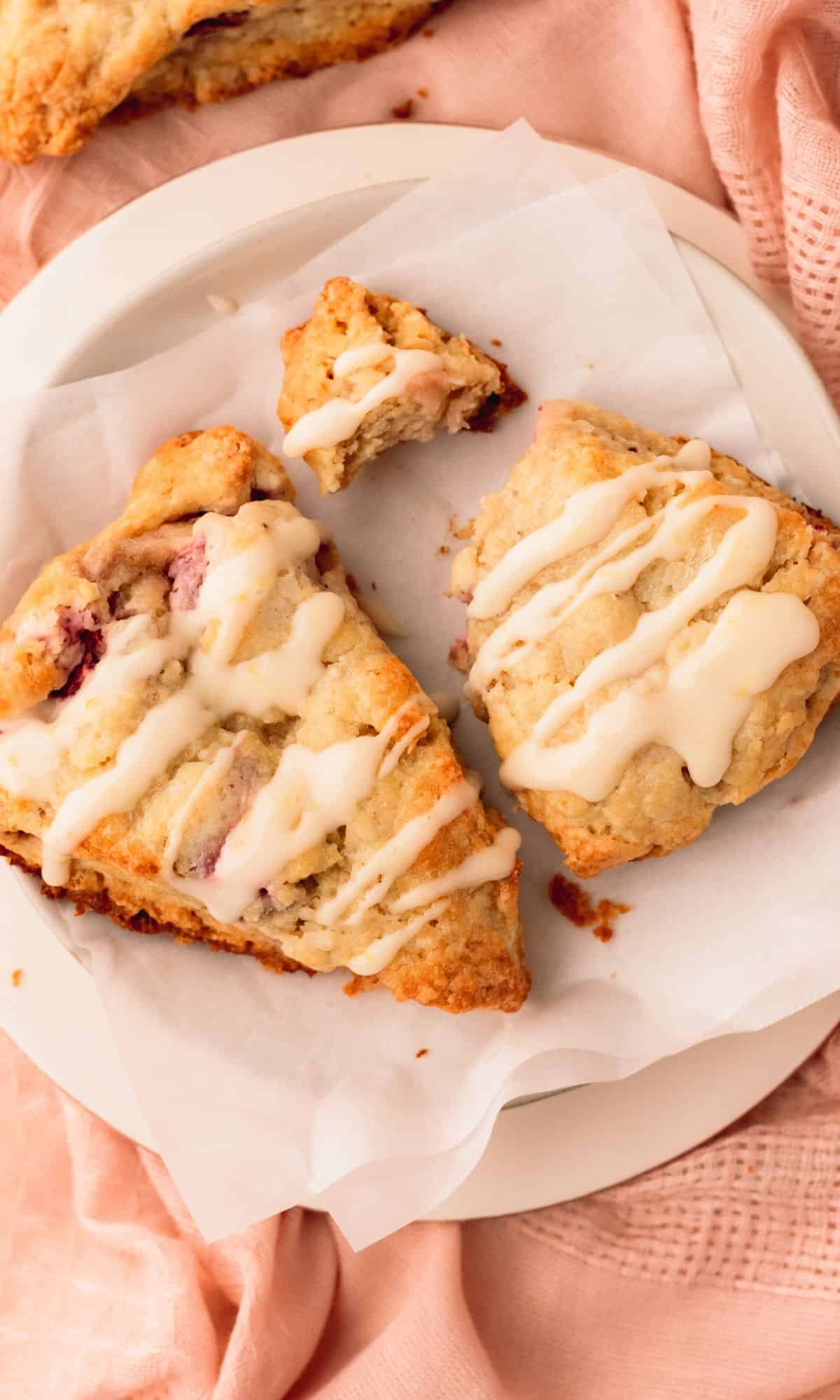 Two strawberry scones on a white plate.