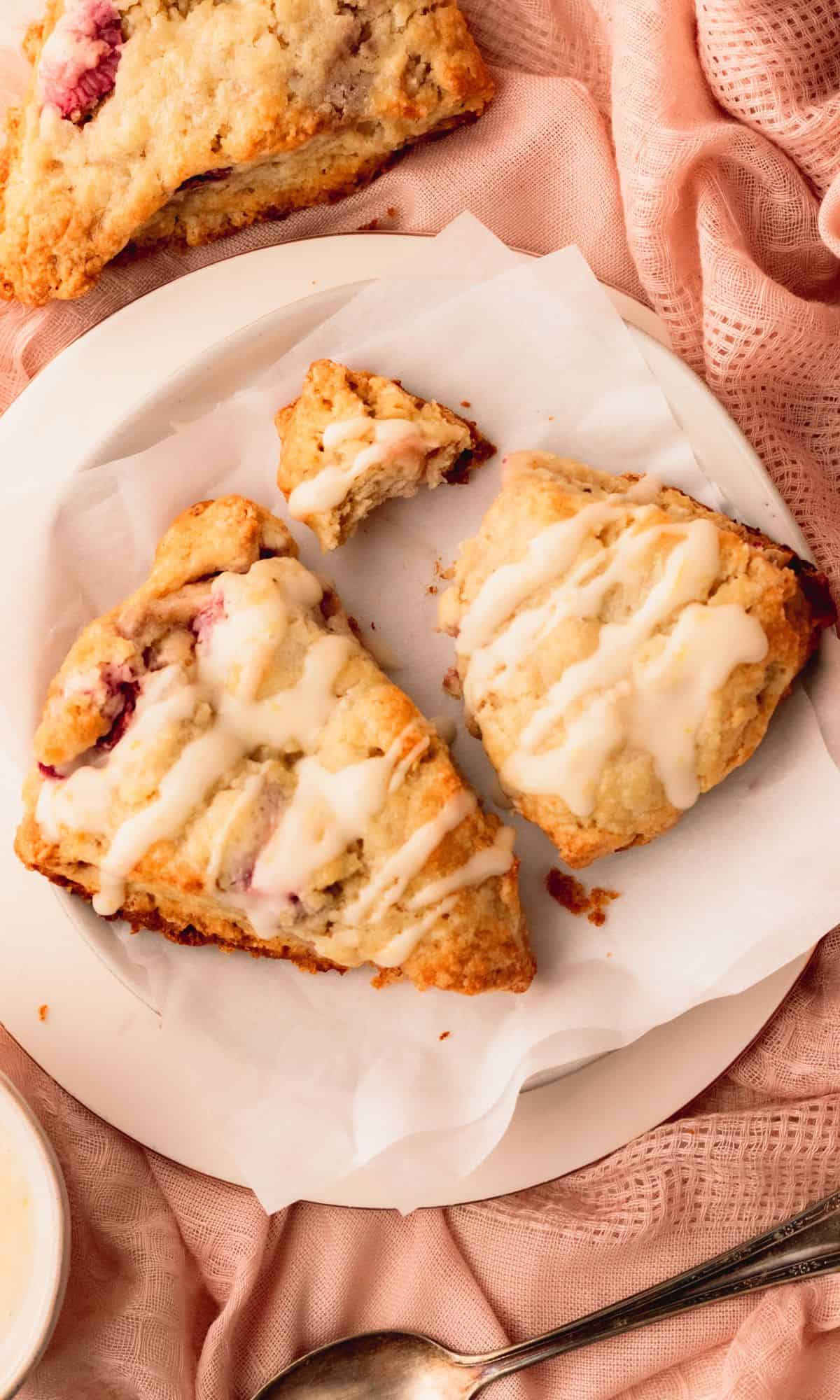 Two strawberry scones on a white plate.