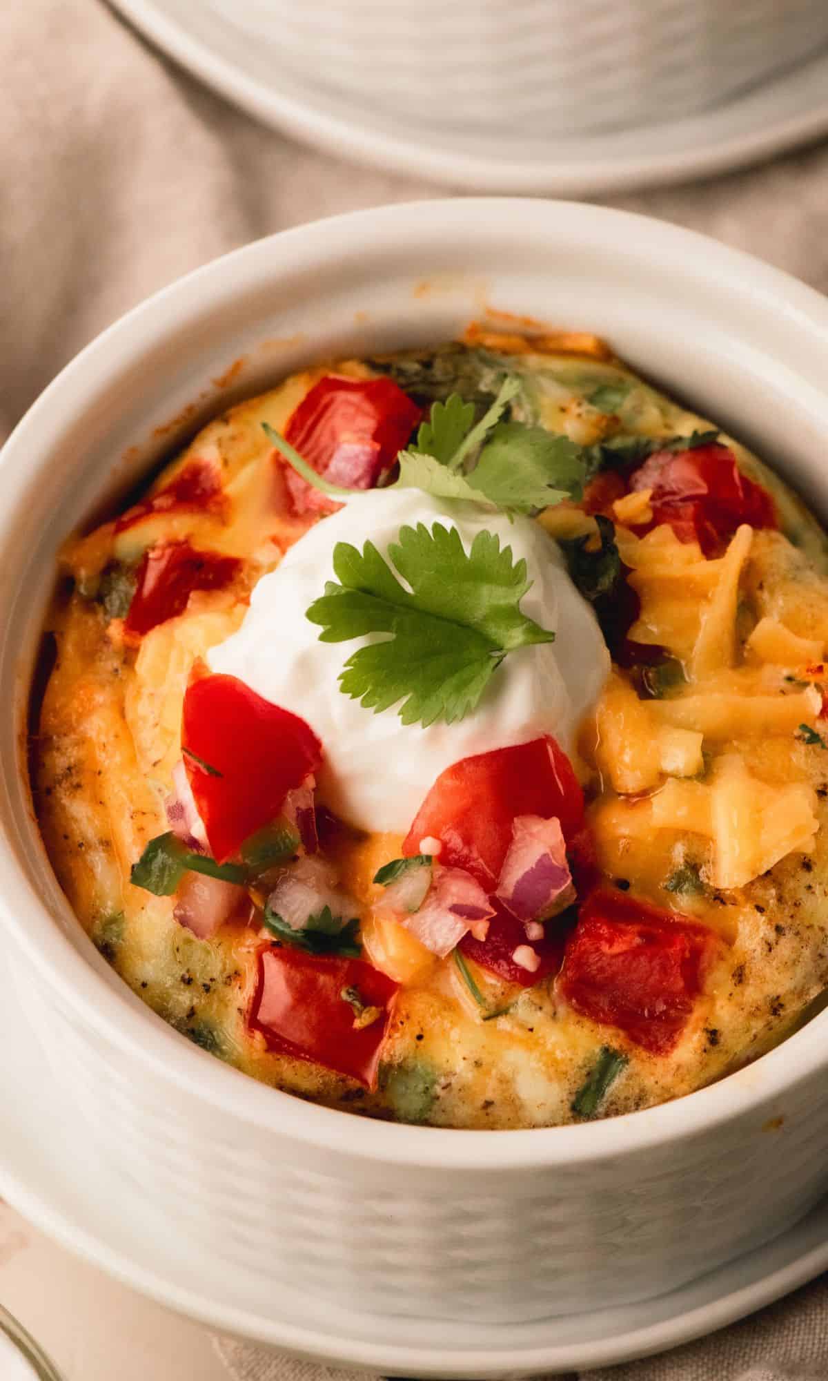 Egg bake in individual ramekins topped with sour cream and cilantro.