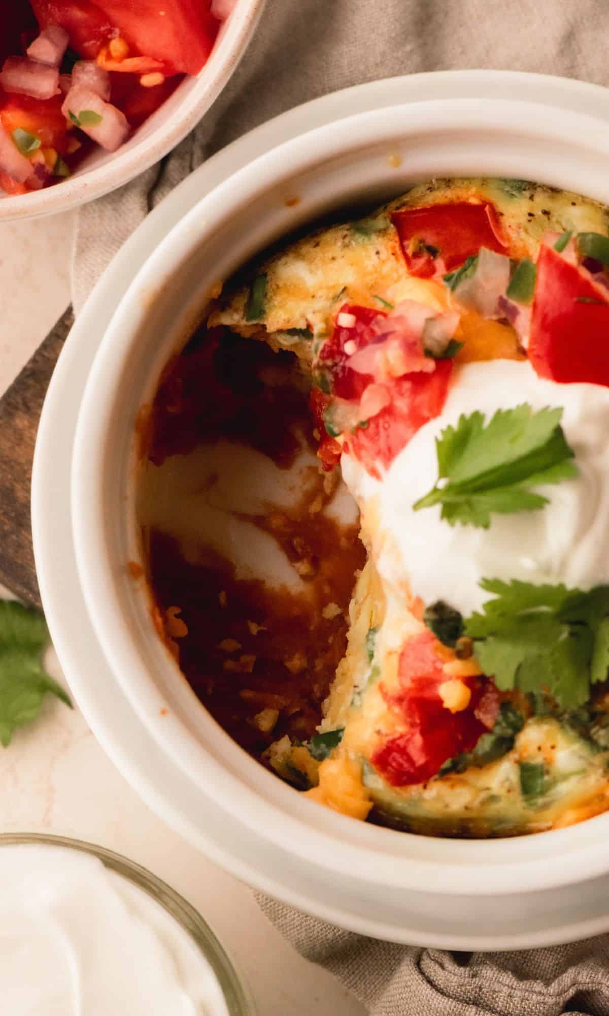 Egg bake in individual ramekins topped with sour cream and cilantro.