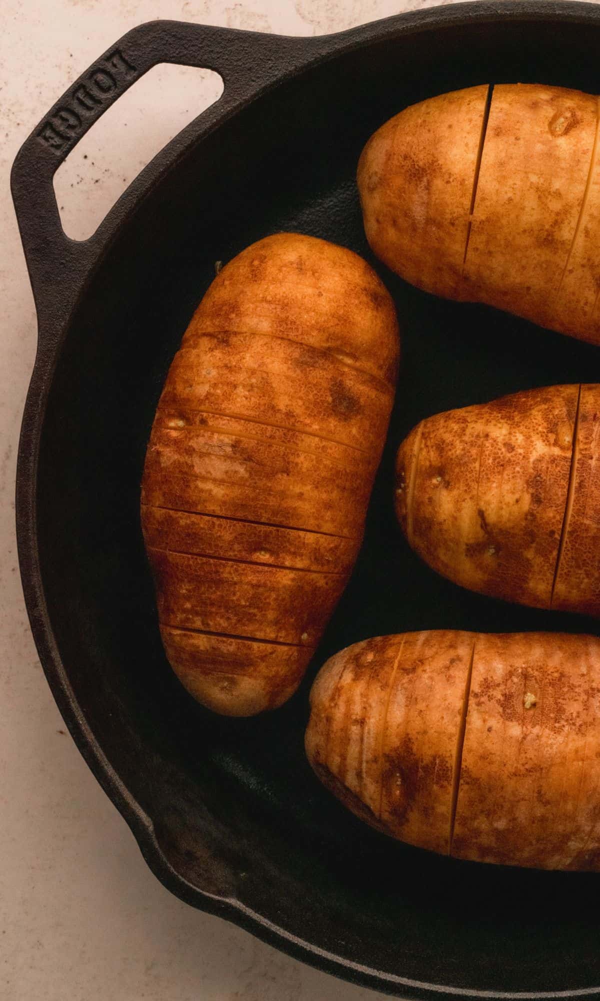 Cut hasselback potatoes in a cast iron skillet.