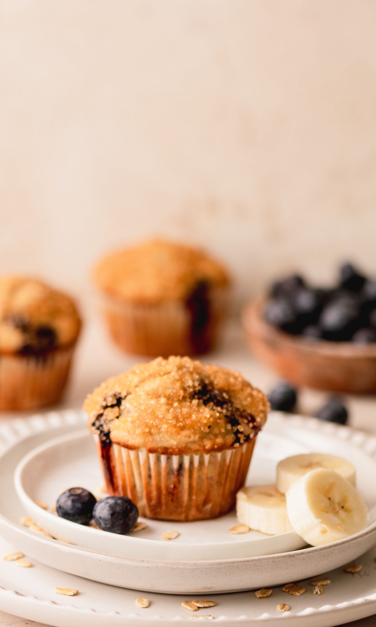 A blueberry banana muffin on a white plate.