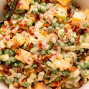 Pasta salad in a white bowl.