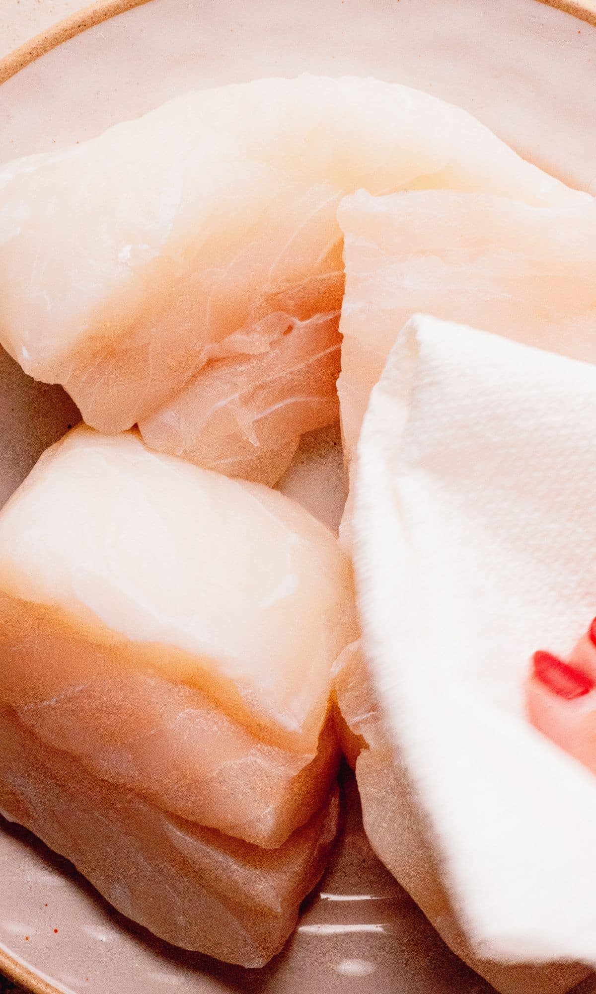 Patting cod dry with a paper towel.