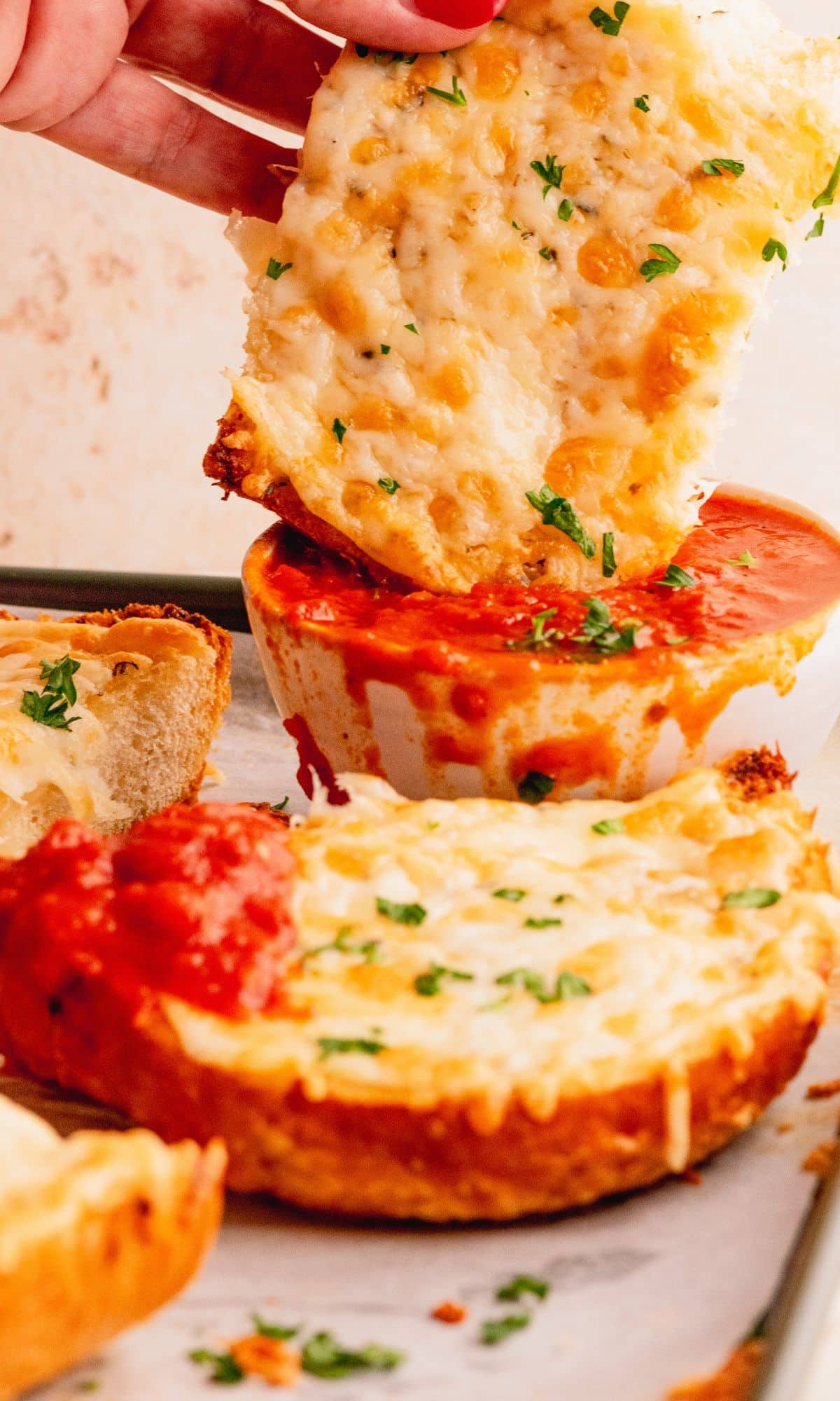 Italian dunker getting dipped in marinara sauce.