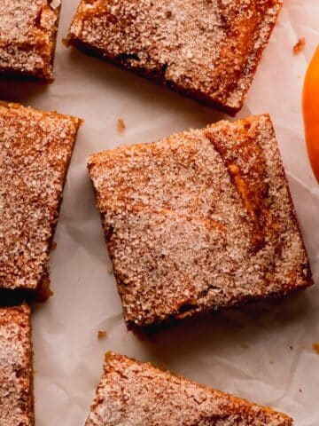 Pumpkin blondies with a cinnamon sugar top cut into squares.