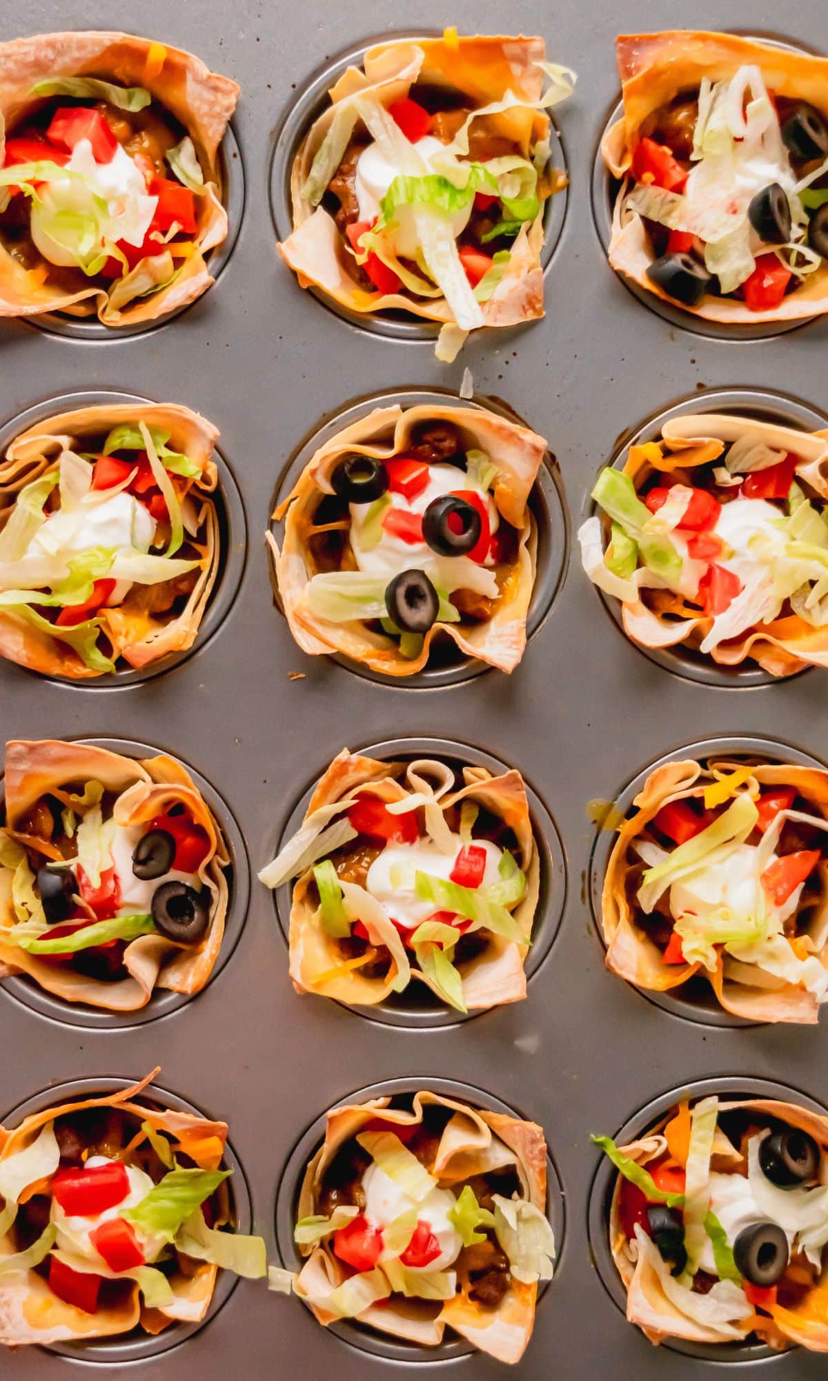 Taco cups topped with taco toppings.