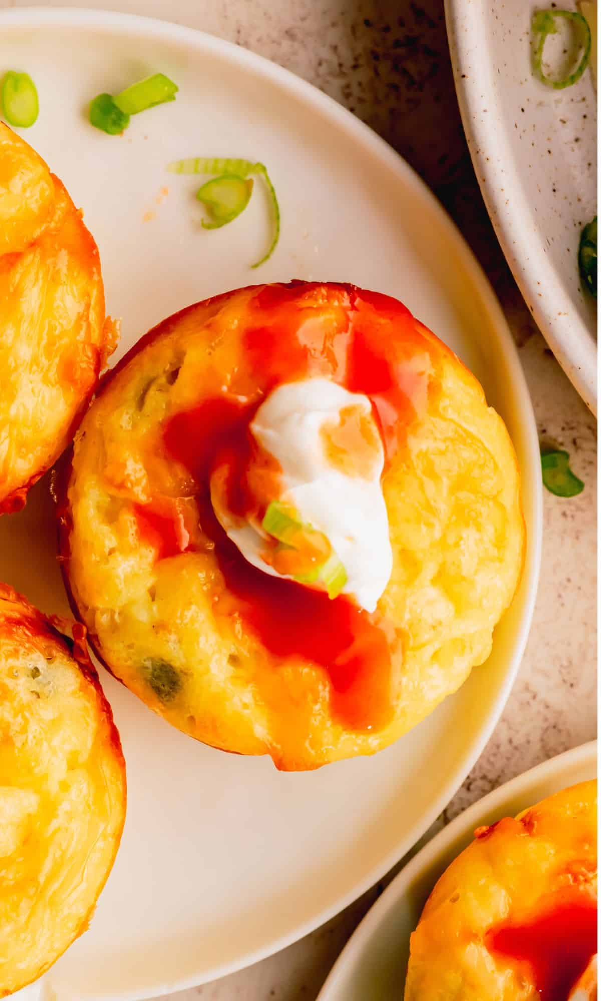 An egg bite topped with sour cream and hot sauce.