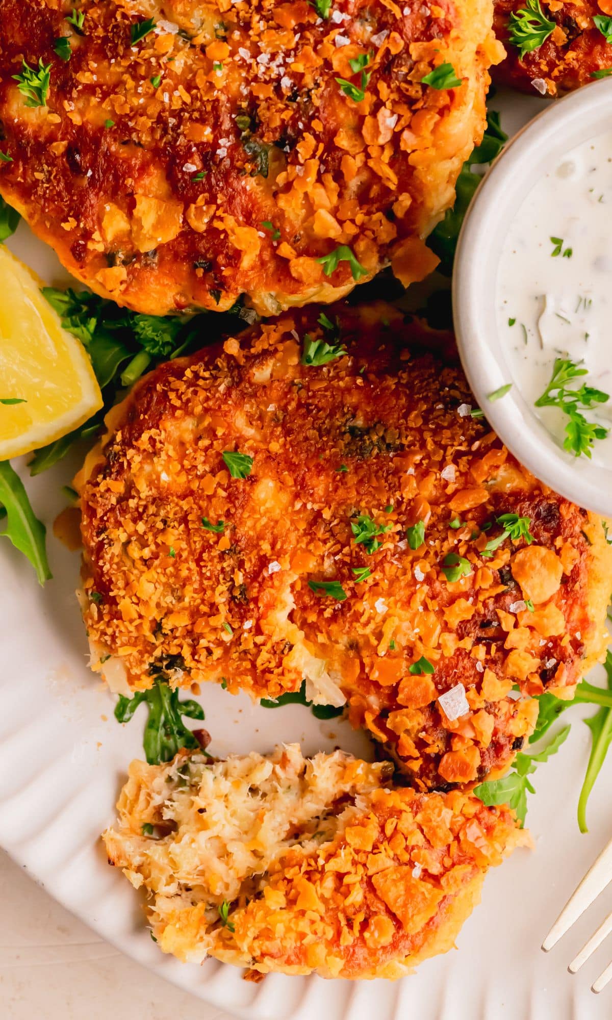 Salmon cakes with a piece cut off.
